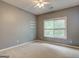 This carpeted bedroom features a ceiling fan and large window for natural light at 2560 Almont Way, Roswell, GA 30076