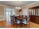 A traditional dining room is furnished with a wooden table, upholstered chairs, a chandelier, and a built-in display cabinet at 2560 Almont Way, Roswell, GA 30076