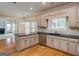 A kitchen is equipped with granite countertops, stainless steel appliances, light-colored cabinets, and hardwood floors at 2560 Almont Way, Roswell, GA 30076