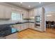 A gourmet kitchen features stainless steel appliances, granite countertops, and hardwood floors; with a view into the dining room at 2560 Almont Way, Roswell, GA 30076