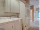Laundry room has white cabinets, washer, and dryer plus a view to hallway at 2560 Almont Way, Roswell, GA 30076