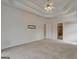 Spacious main bedroom featuring a tray ceiling, carpeted floors, and access to the ensuite bathroom at 2560 Almont Way, Roswell, GA 30076