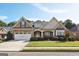 Two-story house with stone and beige siding, a three-car garage, and a landscaped lawn at 348 Relative Trl, Mcdonough, GA 30253