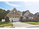 Two-story house with stone and beige siding, a three-car garage, and a landscaped lawn at 348 Relative Trl, Mcdonough, GA 30253