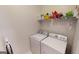 Bright laundry room features a washer, dryer, and shelf with supplies at 1461 Hada Ln, Lawrenceville, GA 30043