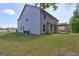 A spacious backyard showing the back of the home and a covered patio at 161 Jodi Pl, Locust Grove, GA 30248