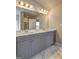 Bright bathroom featuring a double vanity with gray cabinets, a large mirror, and marble-style flooring at 161 Jodi Pl, Locust Grove, GA 30248
