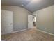 Neutral bedroom featuring carpet flooring, two doors and a partial view of the staircase at 161 Jodi Pl, Locust Grove, GA 30248