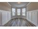 Bright living area featuring wainscoting, large windows, and stylish gray wood flooring at 161 Jodi Pl, Locust Grove, GA 30248