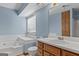 Bathroom featuring built-in tub, vanity sink with wood cabinets and window at 125 Laney Ct, Mcdonough, GA 30252