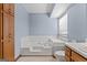 Bathroom features a built-in tub, blue walls, and wood cabinets at 125 Laney Ct, Mcdonough, GA 30252