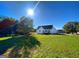 View of a newly constructed home from the back of the large, grass covered, and tree lined backyard at 217 Point Ridge Ct, Temple, GA 30179