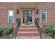 Charming brick home featuring black-trimmed windows and a welcoming glass front door with decorative wreaths at 470 Dix Lee On Dr, Fayetteville, GA 30214