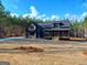 Modern farmhouse with dark siding, stone accents, and a covered front porch at 154 Rainey Rd, Temple, GA 30179