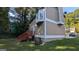 Side view of a home with tan siding, white trim, a small deck, and green lawn at 5300 Forest Downs Ln, Atlanta, GA 30349
