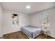 A cozy bedroom with hardwood floors, a decorative wall display, and natural light from the window at 2013 Marco Dr, Decatur, GA 30032