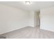 Neutral-toned bedroom with soft carpeting, a large window, and a door leading to a hallway at 4001 Avalon Sw Rd, Atlanta, GA 30331