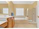 Bathroom with double sinks, a soaking tub with tile surround, and glass shower at 4424 Bellwood Cir, Atlanta, GA 30349