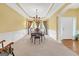 Elegant dining room with chandelier, wainscoting and tray ceiling at 4424 Bellwood Cir, Atlanta, GA 30349