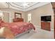 This main bedroom features tan walls, trey ceilings, a ceiling fan, carpet, and dark wood furniture at 4424 Bellwood Cir, Atlanta, GA 30349