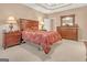 This main bedroom features tan walls, trey ceilings, a ceiling fan, carpet, and dark wood furniture at 4424 Bellwood Cir, Atlanta, GA 30349