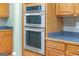Modern kitchen featuring stainless steel double ovens and wooden cabinets at 4424 Bellwood Cir, Atlanta, GA 30349