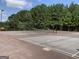 Outdoor tennis court with net and tall trees in the background at 4424 Bellwood Cir, Atlanta, GA 30349