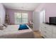 Comfortable bedroom with a window, plush bedding, and white dresser at 2783 Parkway Cv, Lithonia, GA 30058