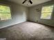 This bedroom features neutral walls, carpeted floors, and two windows letting in natural light at 2177 E Chester Cir, Conyers, GA 30013