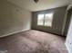 This bedroom features neutral walls, carpeted floors, and a window letting in natural light at 2177 E Chester Cir, Conyers, GA 30013