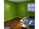 Bedroom with lime green walls, hardwood floors, and a twin bed at 1386 Pineglen Dr, Riverdale, GA 30296