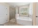 Bathroom showcasing a glass shower, a soaking tub, a window and tile throughout at 527 Bohannon Rd # 12, Grantville, GA 30220