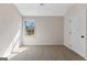 Bright bedroom with a large window offering outside views and carpeted floors leading to a white door at 527 Bohannon Rd # 12, Grantville, GA 30220