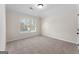 Bright bedroom with a large window offering outside views and carpeted floors leading to a white door at 527 Bohannon Rd # 12, Grantville, GA 30220