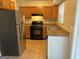 Galley kitchen with wood cabinets, stainless steel appliances, and tile floors at 2570 Picardy N Cir # B, Atlanta, GA 30349