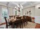 Elegant dining room features a large table, chandelier, and hardwood floors at 140 Haddock Pt, Brooks, GA 30205