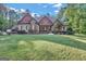 House exterior featuring a stone and shingle two-story home with landscaping at 140 Haddock Pt, Brooks, GA 30205
