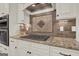 Kitchen detail showing gas cooktop and granite countertop at 140 Haddock Pt, Brooks, GA 30205