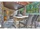 Stone outdoor kitchen with seating area under covered patio at 140 Haddock Pt, Brooks, GA 30205