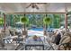 Relaxing covered patio overlooks a luxurious pool and wooded backyard at 140 Haddock Pt, Brooks, GA 30205