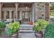 Front porch detail featuring stonework, a wooden door, and potted plants at 140 Haddock Pt, Brooks, GA 30205