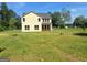 Spacious backyard featuring a yellow two-story home, lush lawn, and beautiful trees at 200 Parker Dr, Mcdonough, GA 30253