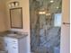 Modern bathroom with marble shower, glass door, granite vanity, and a sleek, well-lit mirror at 200 Parker Dr, Mcdonough, GA 30253