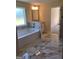 Bathroom features a modern soaking tub with marble accents and luxurious tile flooring at 200 Parker Dr, Mcdonough, GA 30253
