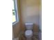 A compact half-bathroom featuring a standard toilet and minimal decor at 200 Parker Dr, Mcdonough, GA 30253