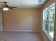 A bedroom with neutral walls and carpeting, a window and a ceiling fan at 200 Parker Dr, Mcdonough, GA 30253
