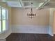 Dining room features coffered ceilings and a modern chandelier for a luxurious dining experience at 200 Parker Dr, Mcdonough, GA 30253