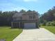 Charming two-story home with a brick facade and driveway surrounded by mature trees at 200 Parker Dr, Mcdonough, GA 30253