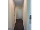Hallway featuring dark wood floors and neutral-colored walls, with multiple doors visible at 200 Parker Dr, Mcdonough, GA 30253