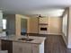 Open-concept space showing the modern kitchen island and cozy fireplace in the living room at 200 Parker Dr, Mcdonough, GA 30253